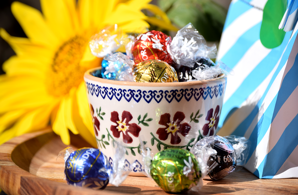 Nicholas Mosse Custard Cup Old Rose filled with lindor lindt chocolate sweets. Sunflower in background