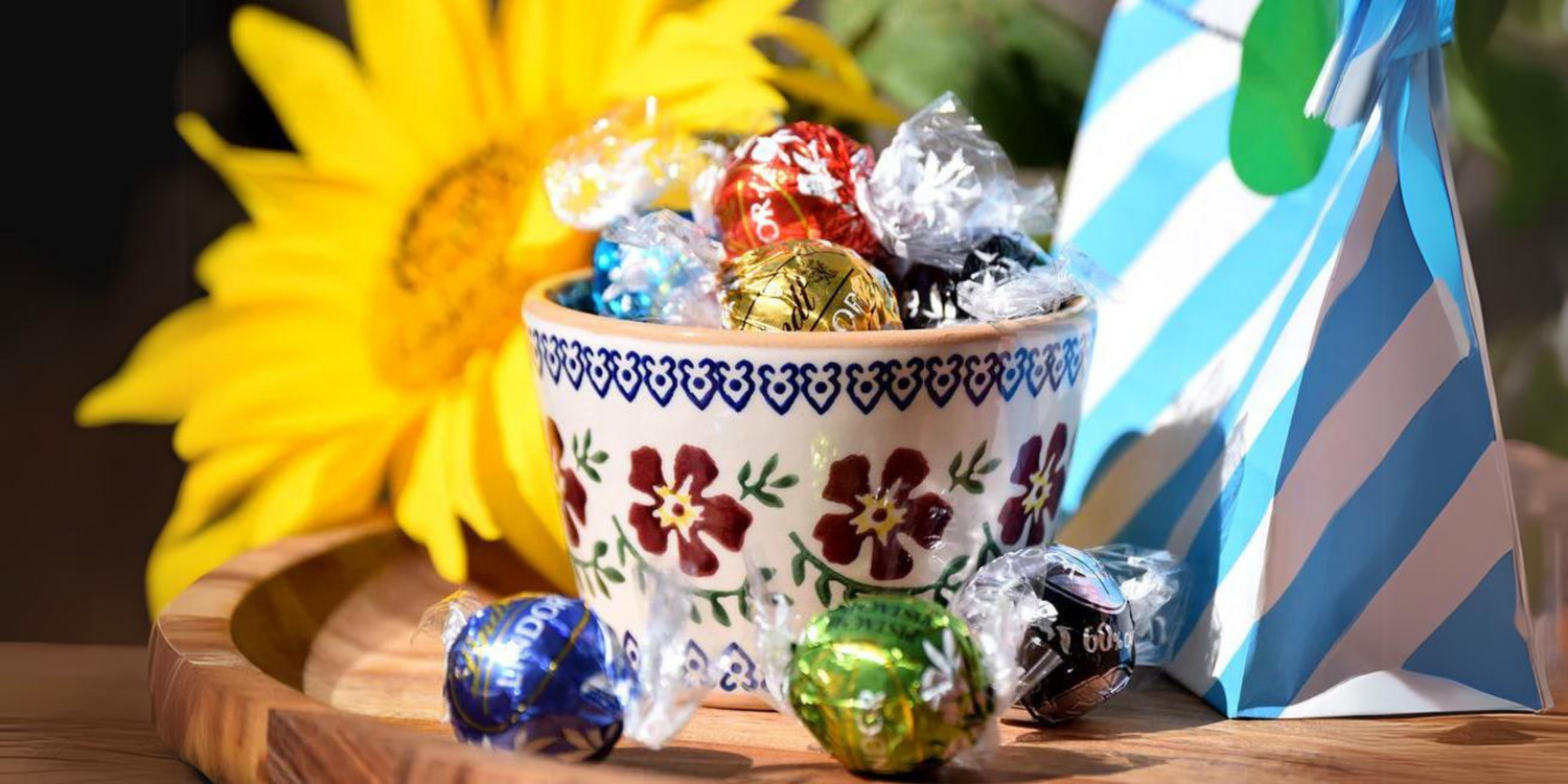 Nicholas Mosse Custard Cup Old Rose filled with lindor lindt chocolate sweets. Sunflower in background